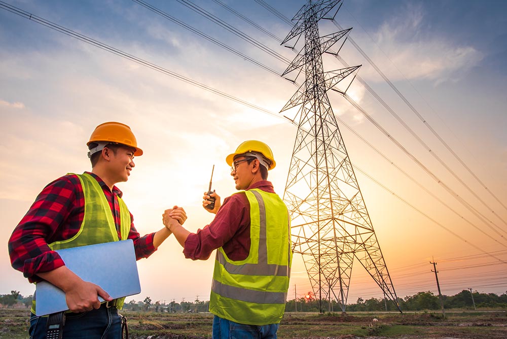two asian men with electrical engineers standing power station standing air shaking hands agreeing production electric power