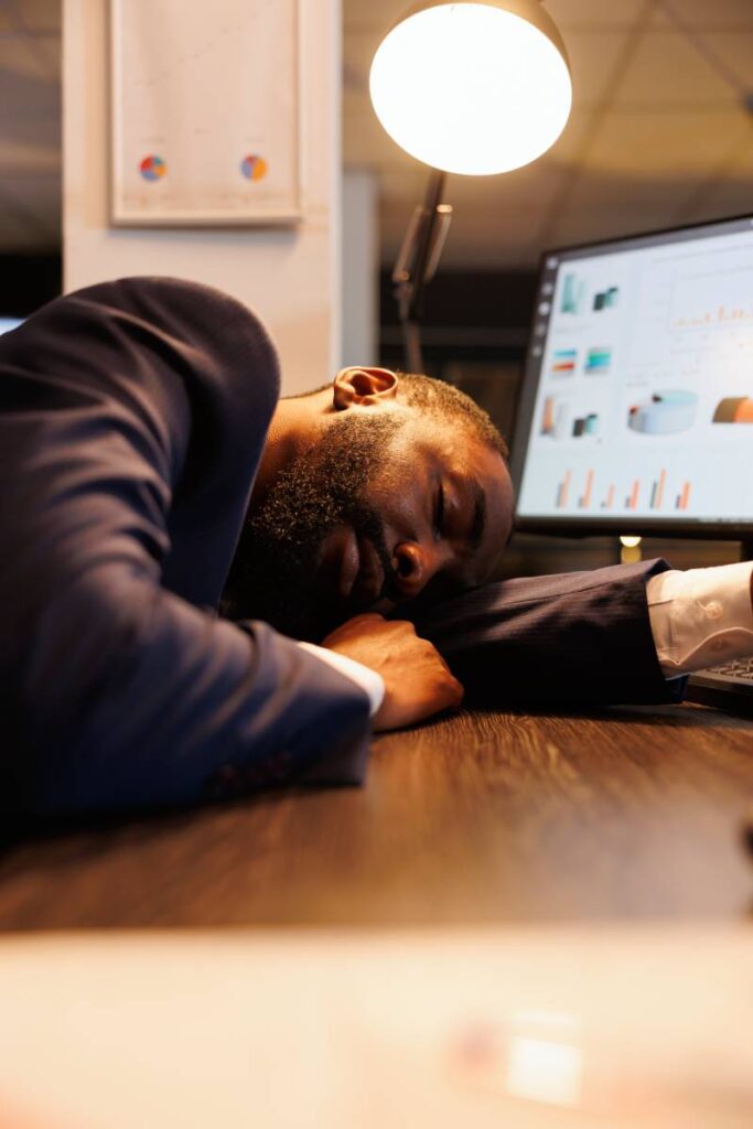 Tired executive manager sleeping on desk in workspace,